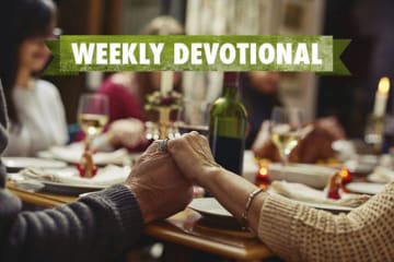 Weekly Devotional: Family praying over a dinner