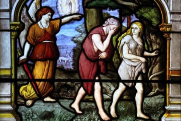 A stained glass image of Adam and Eve