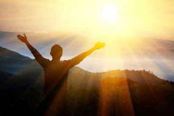 person holding arms out in the sun