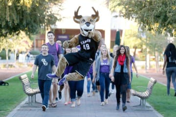 Thunder walking with a group of GCU students on campus