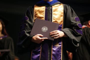 graduate holding diploma