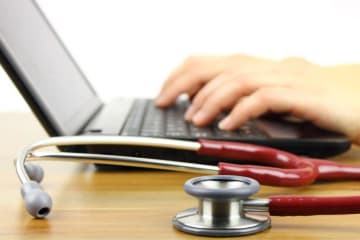 nurse typing on laptop