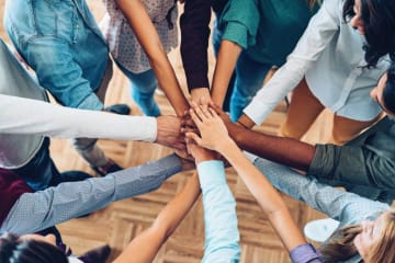 Team members combined hands to promote solidarity