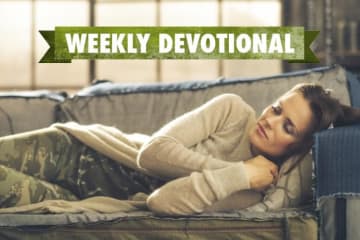 A student sleeping on the couch under a Weekly Devotional banner