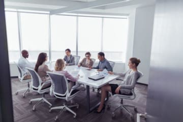 Conference room with professionals reviewing research proposals