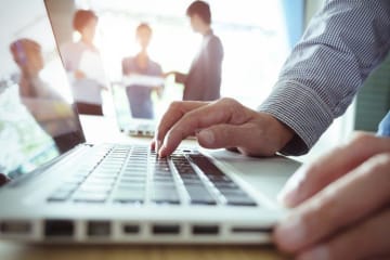 man typing on laptop