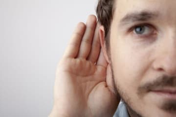 Man holding his hand to his ear to listen