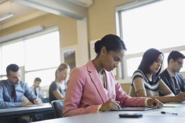 Woman using digital tablet in training class