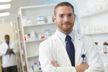 person in lab coat crossing their arms