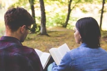Two young adults reading scripture together.