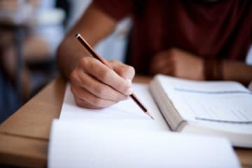 Close-up of notebook textbook and pencil