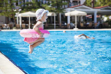 little girl jumping into a pool