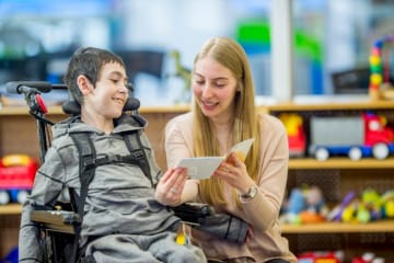 special education teacher helping a student read