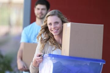 Woman and a man carrying boxes