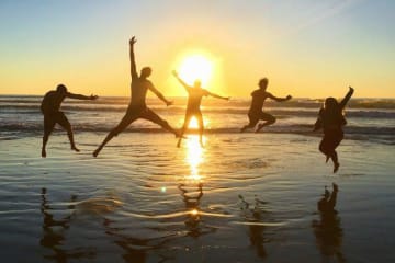 Students holding hands on a trip and posing for a picture