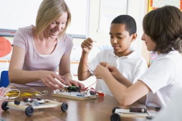 teacher helping students with project