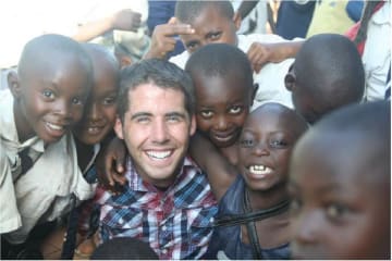 A man surrounded by a group of happy children