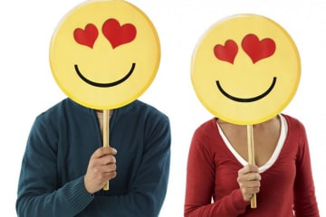 two people holding up heart-eye emojis