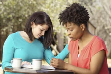 A pair of people conversing and studying