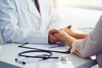 Doctor holding patients hands