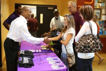 student and adult shaking hands