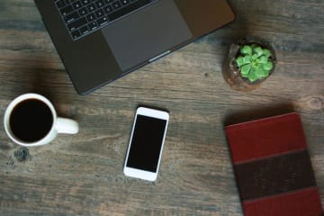 coffee cup phone and book on a table