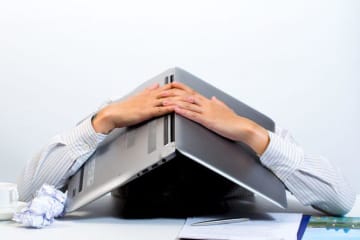 Entrepreneur handling failure poorly with a laptop over his head