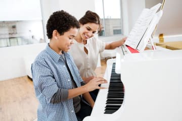 woman teaching piano to a child