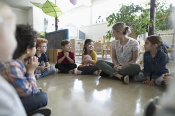 Students and a teacher gathered into a circle