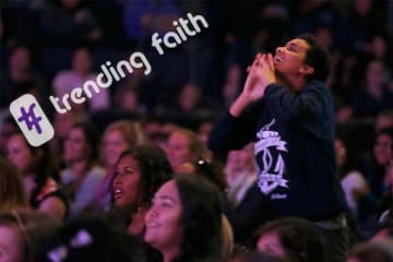 Female student worshiping during Chapel with hashtag trending faith