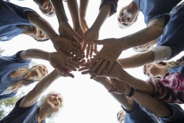 Students piling their hands between them