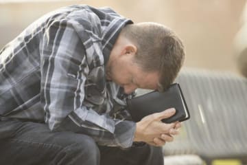 man with head down praying