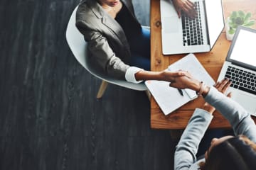 business people shaking hands over a desk