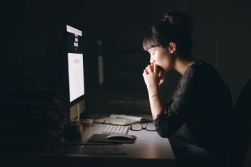 Woman praying and working for the Lord with her computer