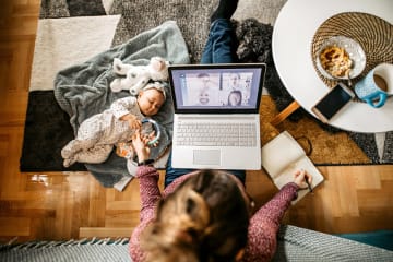 mother flourishing when life is hard by working at coffee table with baby