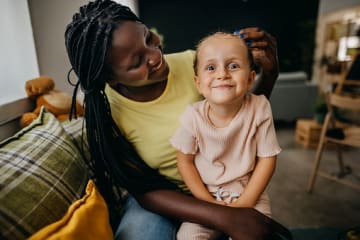 Foster mom sitting and smiling with foster daughter