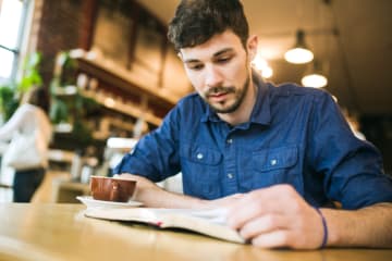 Man reading his Bible in a coffee shop