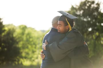 son hugging father after graduating doctoral program