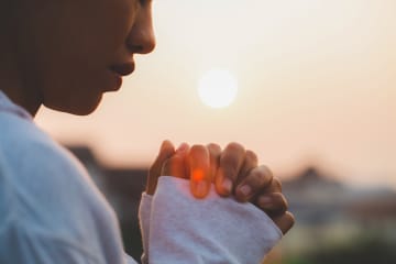 person holding their hands together praying