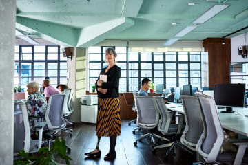 Woman standing in a room with with employees