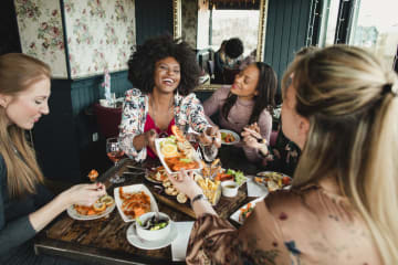 girls laughing and eating brunch