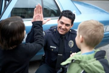 Public safety officer giving kids high-fives