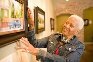 Museum curator inspecting painting