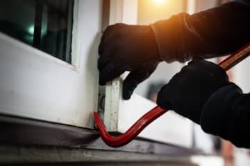 burglar breaking open a door with a crowbar