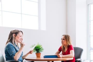 Social worker reading paperwork to young woman