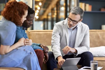 Investment manager helping young couple with their finances 