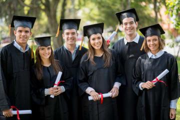 BSBA graduates smiling with their diplomas