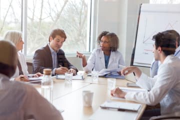 Female doctor discussing qualitative research data with her colleagues 