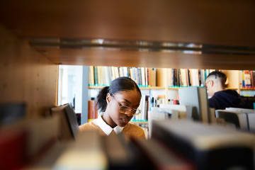 Woman standing in front of bookshelf