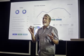 A male professor giving a lecture on quantitative data